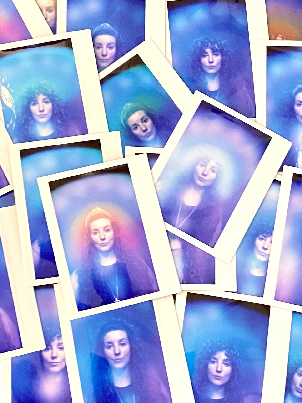 Stack of Polaroid-style portrait photos showing a woman bathed in dreamy blue, purple and pink aura halos, overlapping to create an ethereal studio portrait collage.