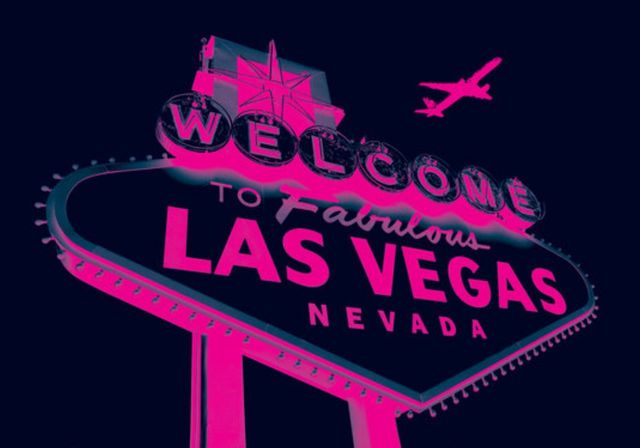 Stylized neon “Welcome to Fabulous Las Vegas Nevada” sign in pink and teal against a dark sky, with a silhouetted airplane flying overhead
