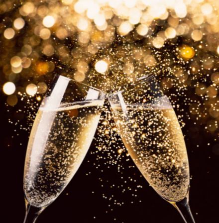 Two champagne flutes clinking mid-toast with sparkling bubbles and golden bokeh lights, festive celebration scene