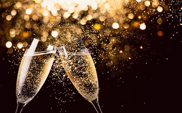 Two champagne flutes clinking with golden bubbles and sparkling bokeh background, festive celebration scene.