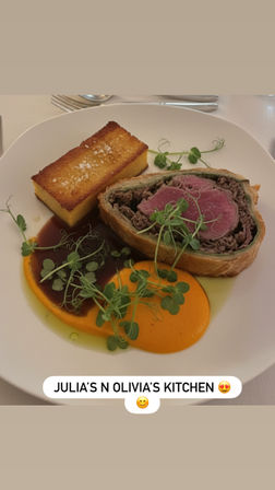 Medium-rare beef Wellington slice in flaky pastry, plated with a golden seared polenta cake, bright carrot purée, rich brown jus and fresh pea microgreens — elegant gourmet entrée.