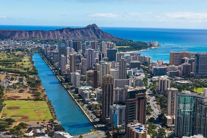 Aerial view of Honolulu skyline with the blue Ala Wai Canal, Waikiki high-rises, Diamond Head crater and turquoise Pacific Ocean