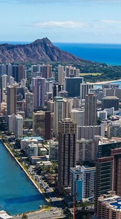 Aerial view of Honolulu skyline with the blue Ala Wai Canal, Waikiki high-rises, Diamond Head crater and turquoise Pacific Ocean