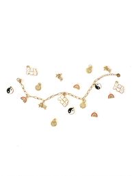 Gold charm bracelet flat lay on white background with removable charms: GRL PWR tags, yin-yang discs, rainbows, stars and sun motifs — boho-chic fashion accessory and gift idea.