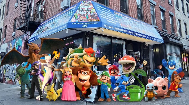 Colorful group of iconic video game characters (Mario, Luigi, Peach, Donkey Kong, Bowser, Pikachu, Charizard, Mewtwo, Sonic, Mega Man, Piranha Plant, Squirtle, Jigglypuff and more) posing on a graffiti-lined city sidewalk in front of a brick storefront with a blue awning.