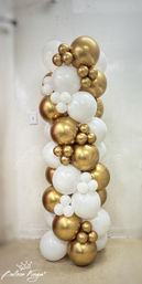 Tall freestanding balloon column garland of white and metallic gold balloons with clustered mini balloons — modern party or wedding event decor against a neutral wall.