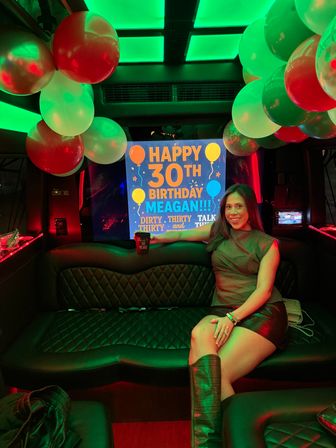 Smiling woman in knee-high boots poses in a neon-green lit party bus interior with balloons and a bright "Happy 30th Birthday" sign.