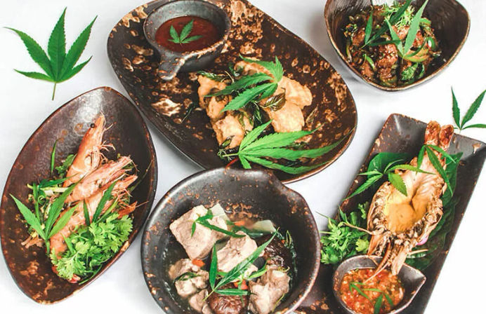 Gourmet Asian-style seafood and meat bowls—shrimp, lobster and braised beef—served in rustic black dishes with dipping sauces and cannabis leaf garnishes