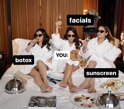Three people in white spa robes and sunglasses lounging on a hotel bed, toasting with champagne; stickers read “botox,” “facials,” and “sunscreen” with a central “you” holding a small dog, surrounded by room‑service plates and a magazine — playful spa day pamper scene.