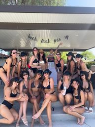Sunlit poolside cabana bachelorette party: group of friends in black bikinis and cowboy hats posing together under a playful party banner