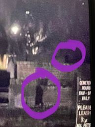 Grainy nighttime CCTV-style photo of a shadowy human-shaped silhouette on a sidewalk by a fence, with a smaller shape and both areas circled in purple and a partial 'please leash' pet sign visible on the right.