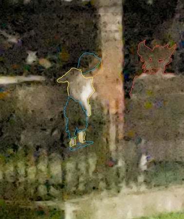 Grainy nighttime backyard scene with a small humanoid figure outlined in blue and yellow wearing a hat and boots next to a wooden post and fence, and a red-outlined dog-like face sketched on the right