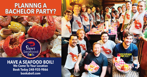 Group of smiling men at a bachelor party on a wooden porch enjoying a catered seafood boil—lobster, crab, corn and sausage on checkered tables, many wearing bibs.