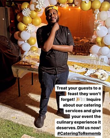 Chef in black coat posing by a gold-and-white balloon arch and dessert table at an outdoor evening catered celebration, promoting catering services.