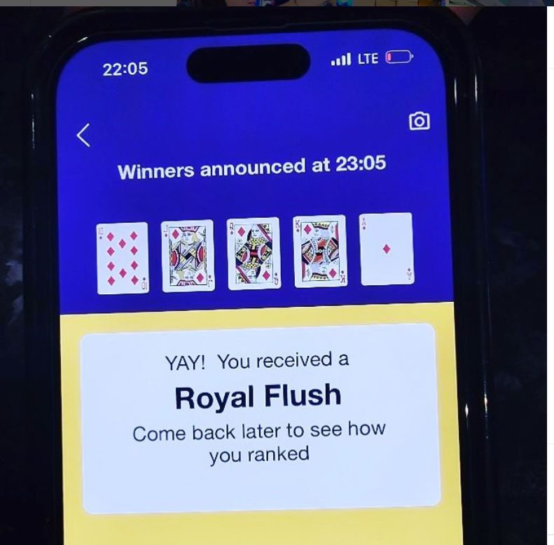Mobile phone screenshot of an online poker app announcing a Royal Flush — 10, J, Q, K, A of diamonds — 'Winners announced at 23:05' with a celebratory message.