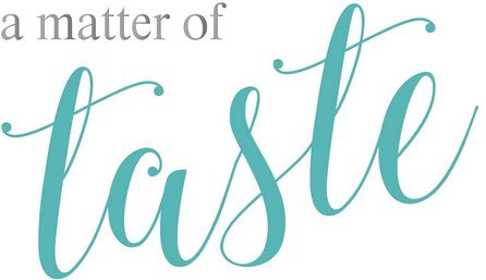 Playful stylized wordmark reading 'a matter of taste' — small gray serif 'a matter of' above large teal calligraphy 'taste' on a white background.