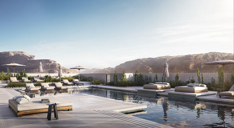 Luxury outdoor pool at a modern desert oasis with plush daybeds, sun loungers and umbrellas beside reflective water, framed by rocky canyon cliffs under soft sunlight.