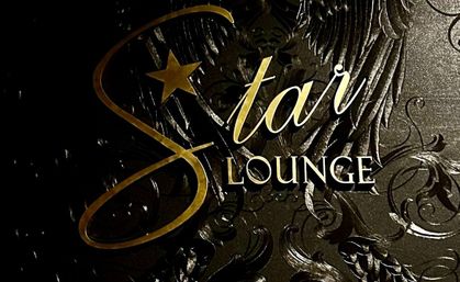 Gold metallic script and serif lettering with a star icon on an embossed black decorative background featuring wing and floral scroll motifs — elegant lounge sign