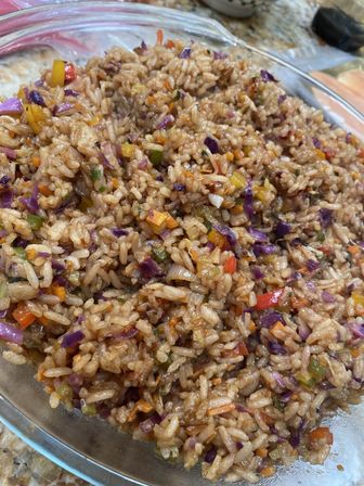 Vibrant homemade vegetable fried rice — soy-glazed rice with purple cabbage, diced carrots and red/yellow bell peppers in a glass bowl.