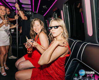 Friends in red dresses enjoying drinks on a pink neon-lit party bus in Las Vegas, playful vibe with pixelated sunglasses and laughter