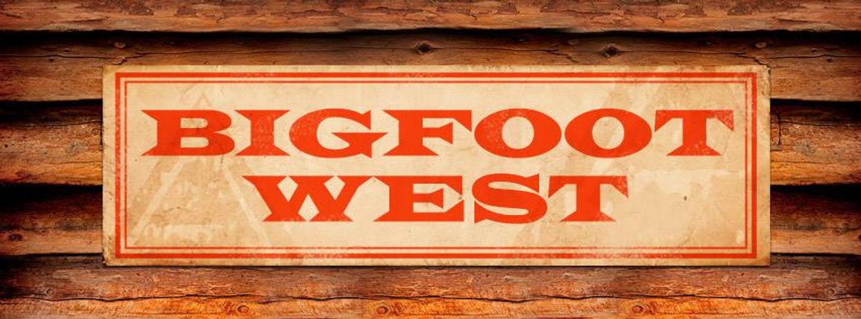 Vintage rectangular sign reading "BIGFOOT WEST" in bold red letters mounted on a weathered log cabin wall