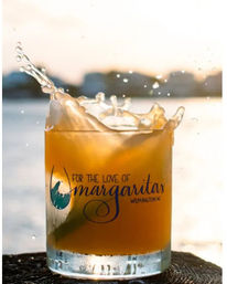 Sunset margarita splash in a rocks glass on the Wilmington, NC waterfront — orange cocktail with midair droplets and coastal sunset glow