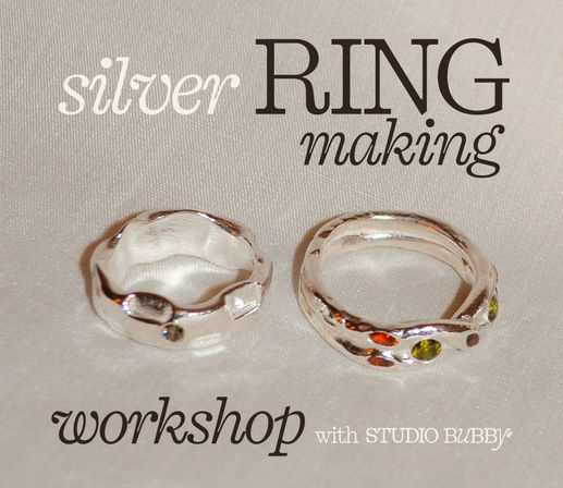 Two handcrafted silver rings on ivory fabric — a wavy band set with small green and orange stones and a textured plain band — promotional image for a DIY silver ring-making workshop.