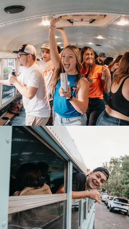 Smiling group of young adults partying inside a converted school bus with canned drinks, one leaning out the window making a shaka sign as the bus sits on a tree-lined neighborhood street.