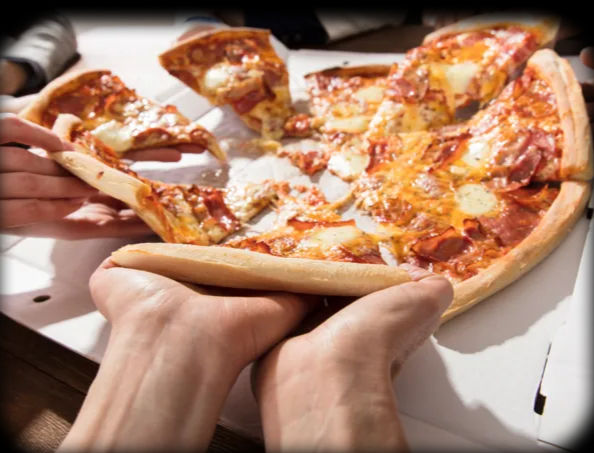 Hands pulling cheesy pepperoni pizza slices from an open white delivery box, group sharing a hot takeout pie