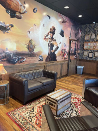 Steampunk-themed interior lounge with large mural of a goggles-wearing Victorian woman and airships, tufted leather sofa, patterned rug and trunk coffee table.