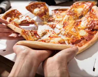 Close-up of hands pulling cheesy pepperoni pizza slices from an open delivery box