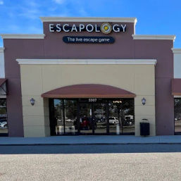 Suburban strip-mall storefront for an escape-room entertainment venue — beige and terracotta facade with an awning over glass double doors reflecting the parking lot.