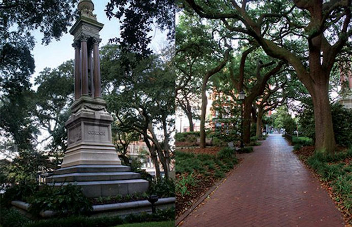 Stone monument beside an oak-lined brick pathway under a leafy tree canopy in a shaded city park with benches and lampposts.