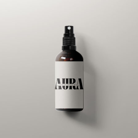 Sleek amber glass spray bottle with a minimalist white label and bold black text, centered on a light gray background with a soft shadow — product mockup for a room or fragrance spray.