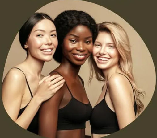 Studio portrait of three smiling women with varying skin tones in black camisoles posing closely against a neutral beige backdrop — diverse beauty and skincare concept.