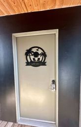Gray exterior door with black metal beach-themed 