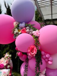 Outdoor pink and lavender balloon garland with faux roses and trailing greenery, bright backyard garden party decor