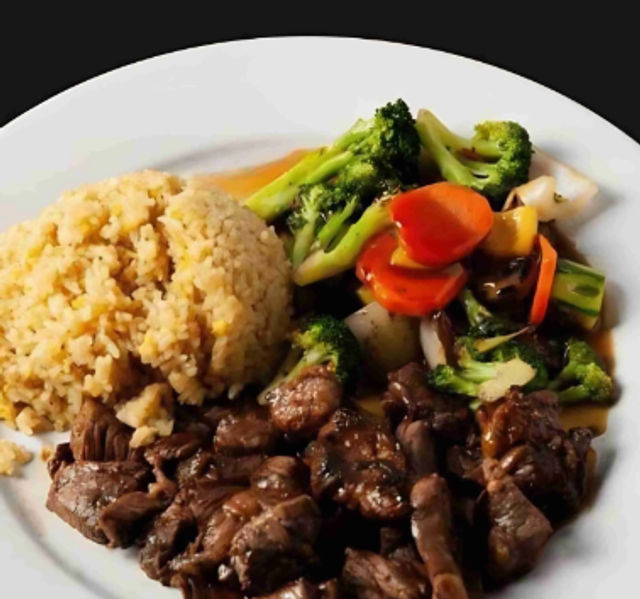White plate with savory beef stir-fry in brown sauce, steamed broccoli, carrots and bell peppers, and a mound of brown rice — restaurant-style dinner.