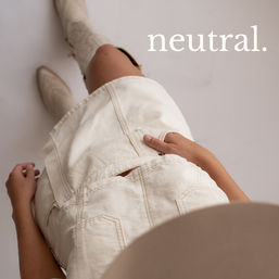 Top-down studio shot of a neutral-style cream denim mini dress and beige cowboy boots on a light backdrop, with the word 'neutral.' in the corner.