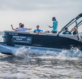 Group of friends enjoying a pontoon boat cruise on a sunny summer lake, splashing through the wake — waterfront boat rental party