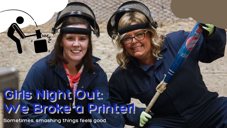 Two women in protective face shields and coveralls smile in an indoor smash room; one holds a baseball bat beside a hammer-smash icon and the overlay text "Girls Night Out: We Broke a Printer!"