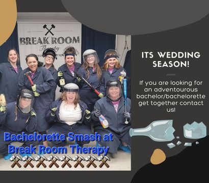 Smiling bachelorette party group wearing protective coveralls, face shields and gloves, holding bats and bottles after an indoor smash room session