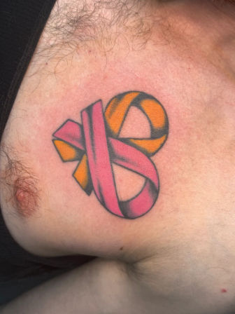 Close-up of a colorful interwoven ribbon tattoo on the upper chest, pink and orange loops with bold black shading