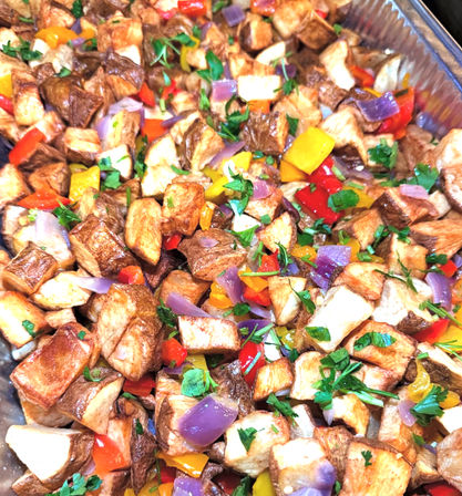 Roasted diced potatoes with colorful bell peppers, purple onion and chopped parsley served in an aluminum catering tray