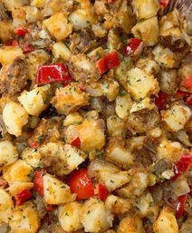 Crispy golden-brown breakfast potatoes (home fries) with diced red bell pepper, sautéed onions and parsley, seasoned roasted potato cubes