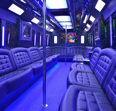 Interior of a luxury party bus with blue LED ambient lighting, tufted leather bench seats lining both sides, mirrored ceiling, disco laser lights, chrome dance poles — ready for a night out.