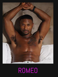 Shirtless muscular man reclining on a bed with arms raised, chest tattoo and defined abs in a sultry bedroom portrait, magenta caption reading ROMEO