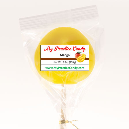 Bright yellow mango lollipop on a stick, wrapped in clear cellophane with a "Mango" label and mango illustration, tied with a gold twist tie on a white background.