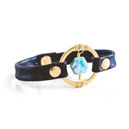 Black leather snap bracelet featuring a gold circular ring wrapped with wire and a blue-green marbled hexagon bead centerpiece — boho chic women's fashion accessory