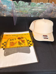 Vendor table with a beige trucker hat and a clear organizer holding colorful iron-on patches and a 'Pick Your Patches' sign.